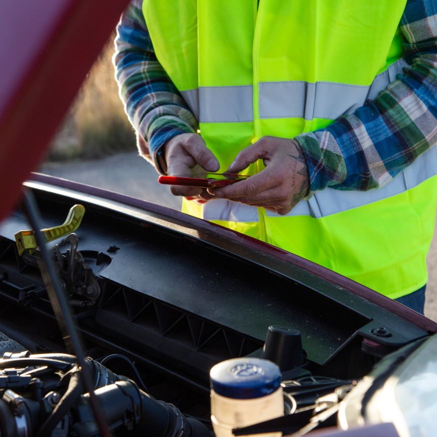 holding his car hood open and send a mechanic because car broke down in the middle of the road